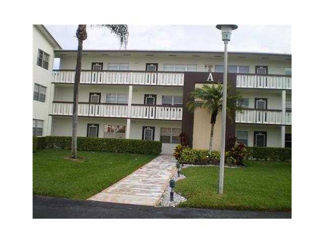 21 Suffolk A, Unit 21 Boca Raton, FL 33434 - Photo 1 of 7 a front view of a house with a yard