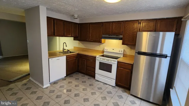 a kitchen with a refrigerator sink and cabinets