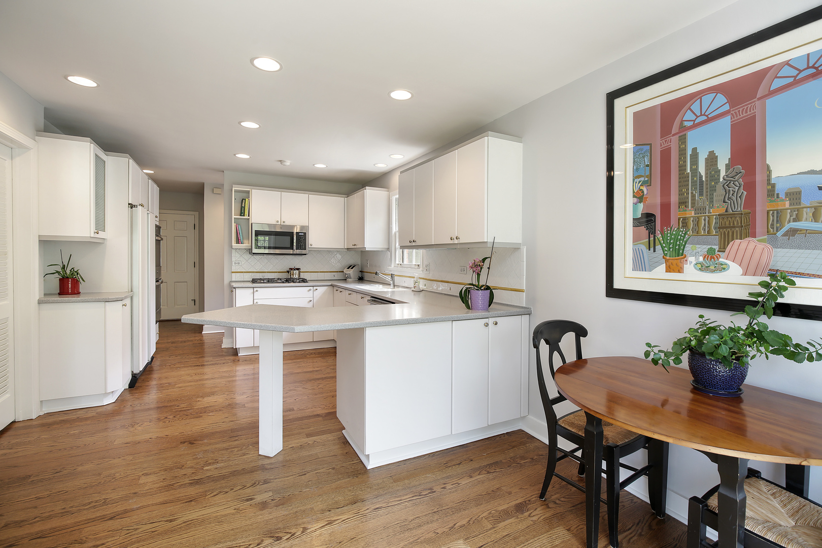 1115 West Deerpath Road Lake Forest, IL 60045 - Photo 4 of 18 a kitchen with stainless steel appliances granite countertop a stove a refrigerator a sink dishwasher a dining table and chairs with wooden floor