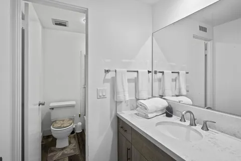 a bathroom with a granite countertop sink toilet a mirror and shower