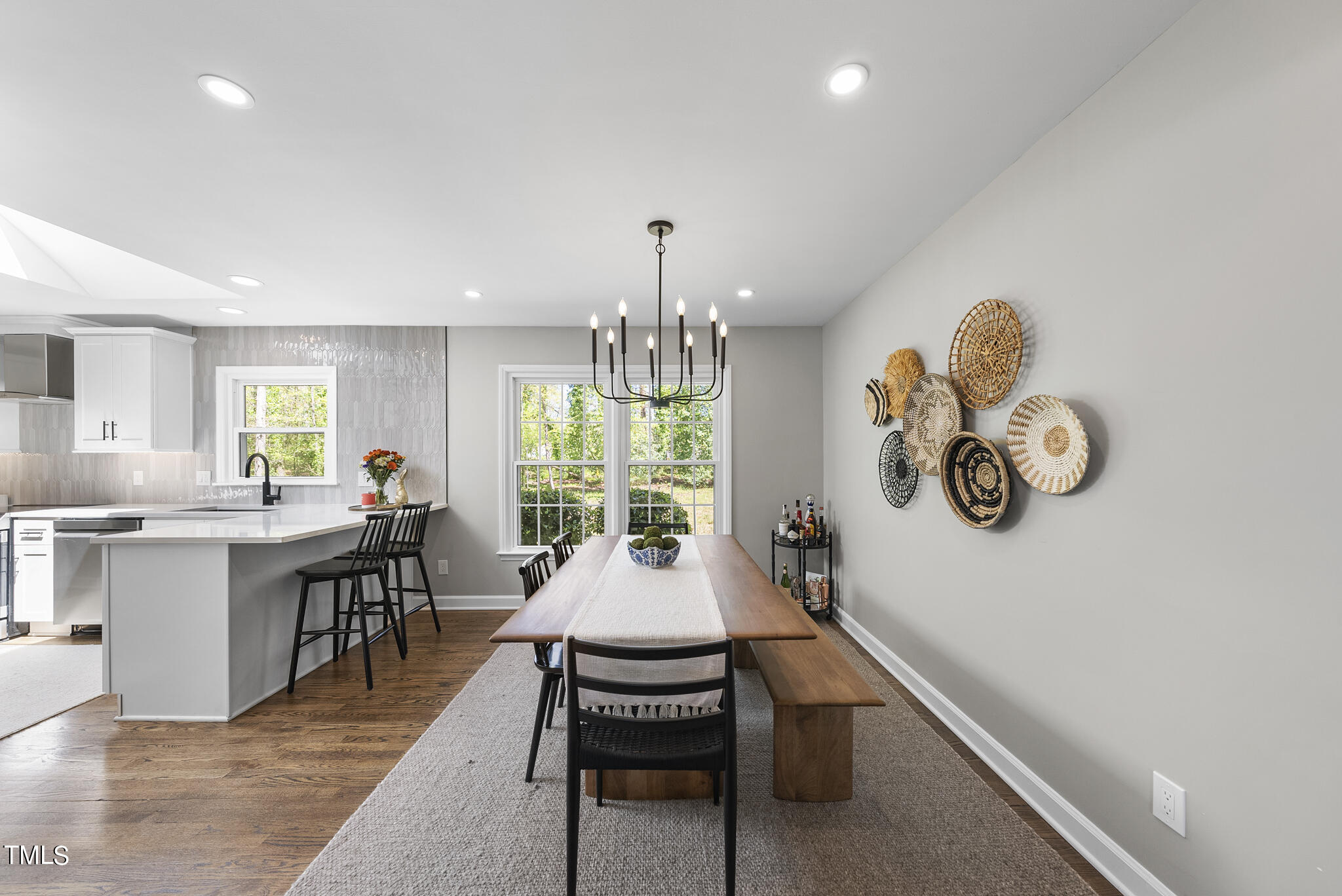 509 Dartmouth Road Raleigh, NC 27609 - Photo 8 of 34 a dining room with wooden floor a chandelier windows and kitchen view