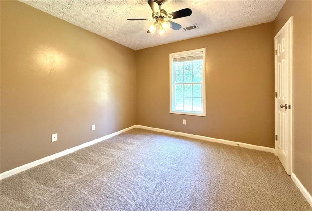 6258 Southern Magnolia Lane Lula, GA 30554 - Photo 8 of 17 an empty room with a window and a fan