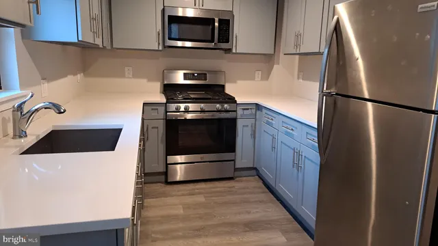 a kitchen with stainless steel appliances a refrigerator stove and microwave