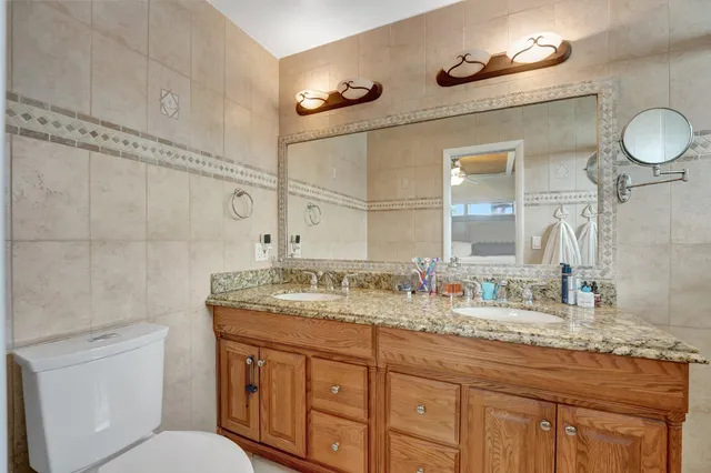 a bathroom with a granite countertop sink a mirror and shower