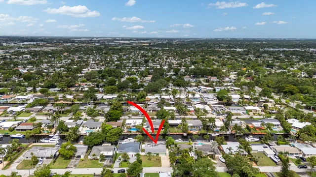an aerial view of residential houses with outdoor space and trees