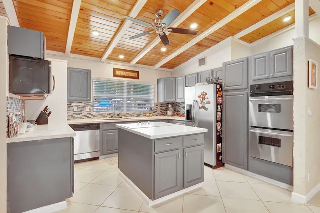 a kitchen with cabinets and chairs
