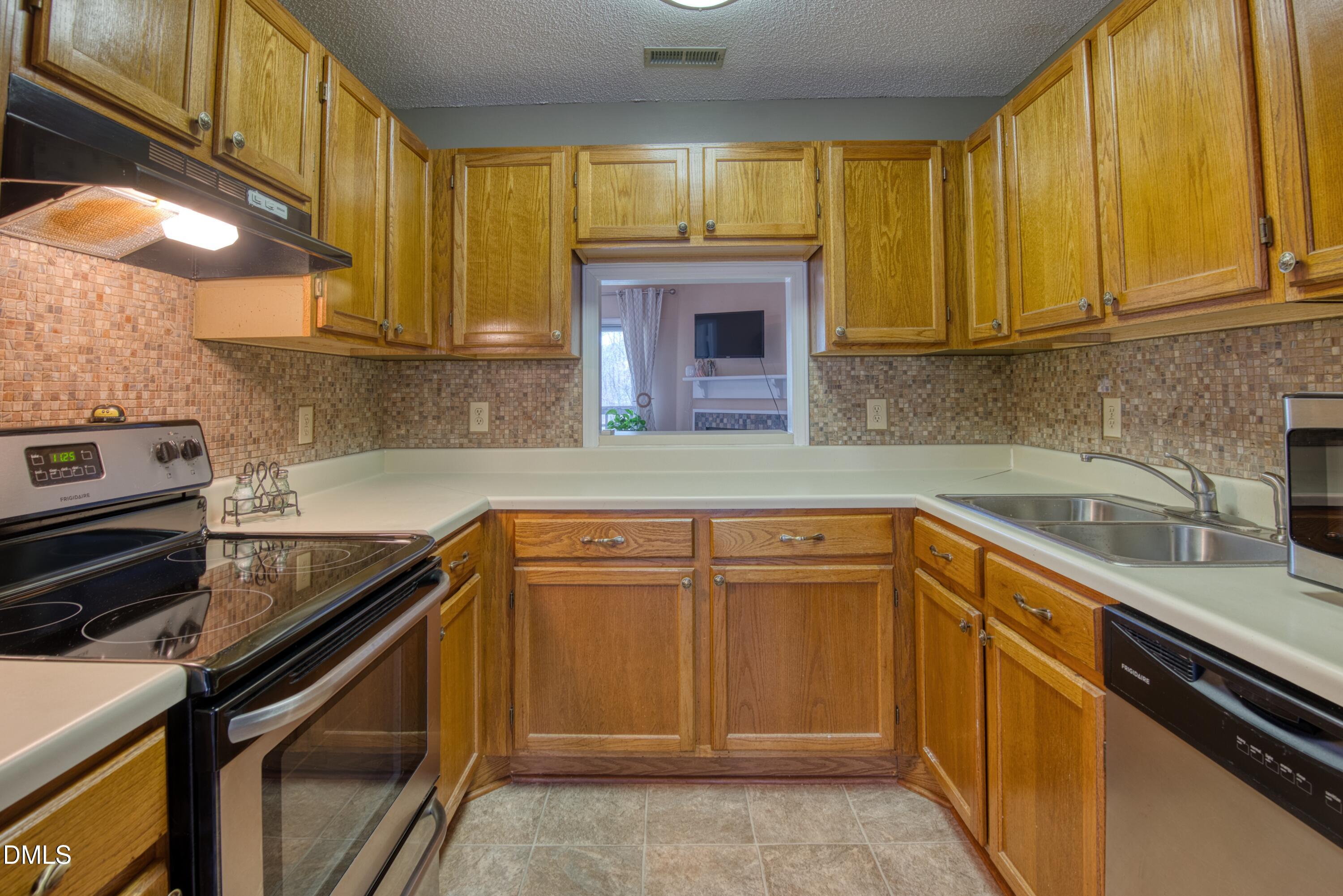 4641 Timbermill Court, Unit 302 Raleigh, NC 27612 - Photo 10 of 27 a kitchen with granite countertop cabinets stainless steel appliances and a sink