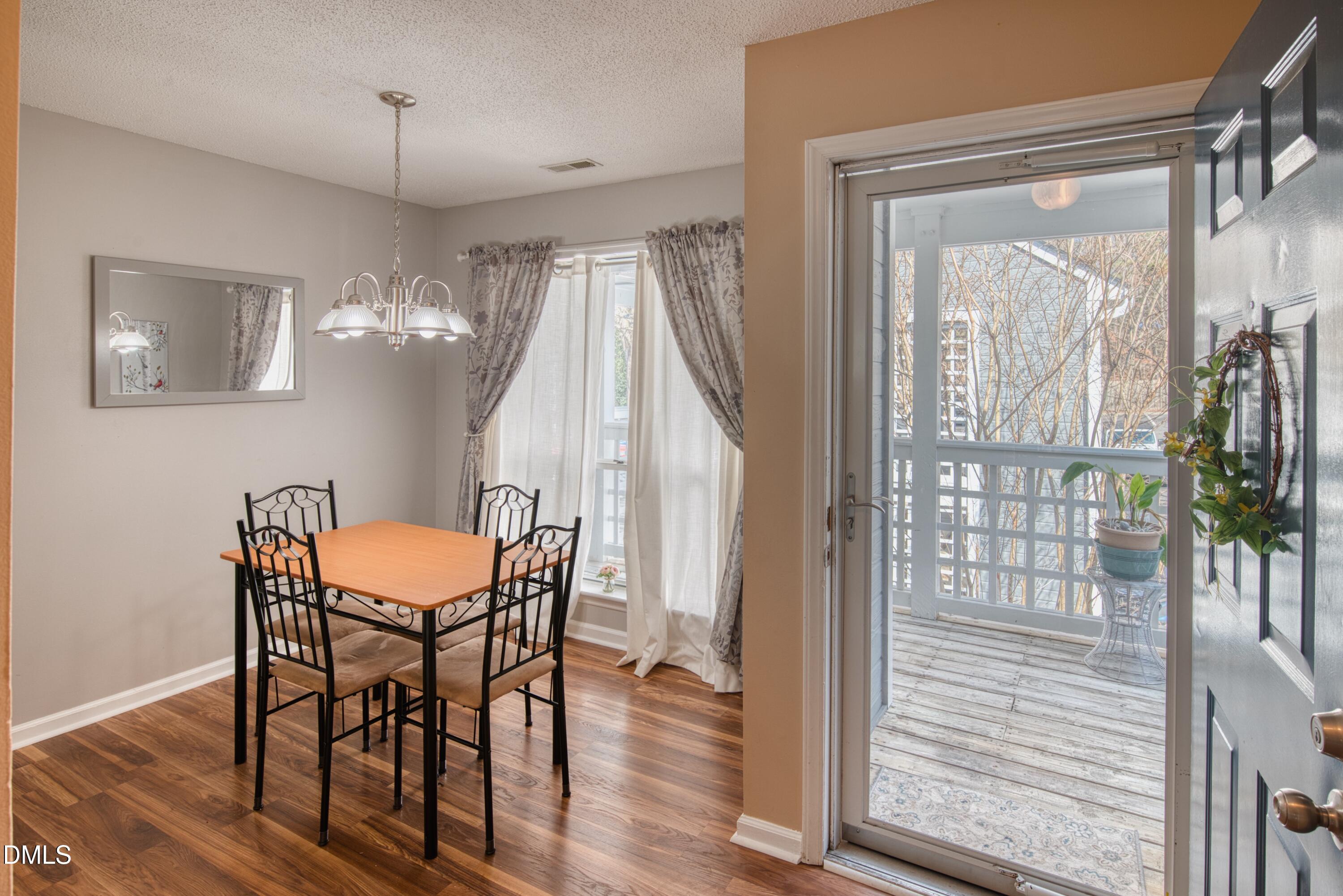 4641 Timbermill Court, Unit 302 Raleigh, NC 27612 - Photo 6 of 27 a dining room with wooden floor a glass table and chairs