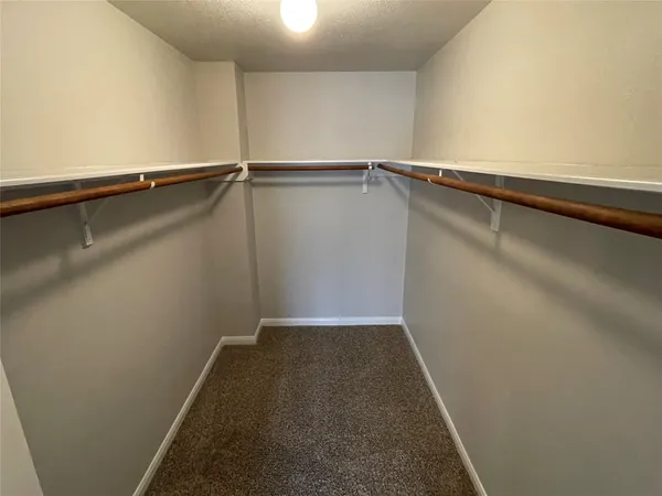 an empty room with windows and chandelier fan
