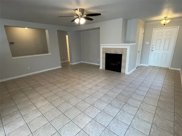 an empty room with windows and fireplace