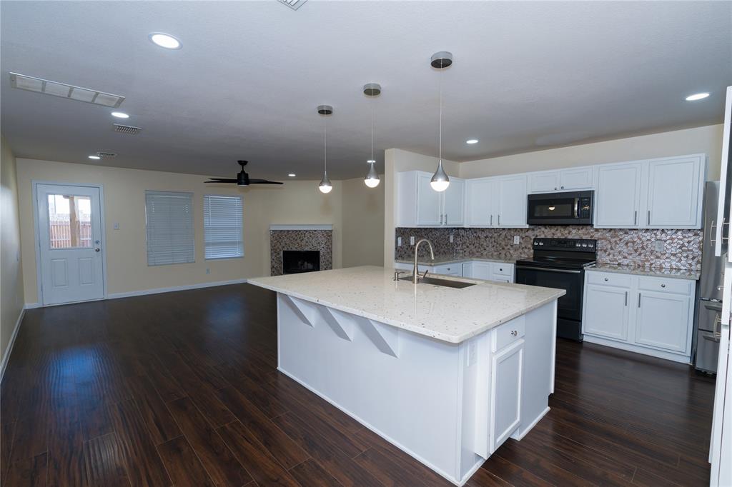 1717 Shawnee Trail Allen, TX 75002 - Photo 11 of 35 a large kitchen with stainless steel appliances kitchen island a stove and a wooden floors