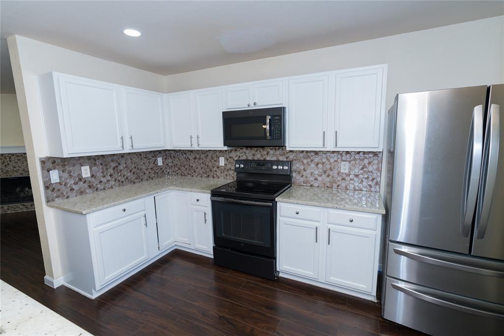 1717 Shawnee Trail Allen, TX 75002 - Photo 2 of 35 a white kitchen with granite countertop stainless steel appliances and wooden floor