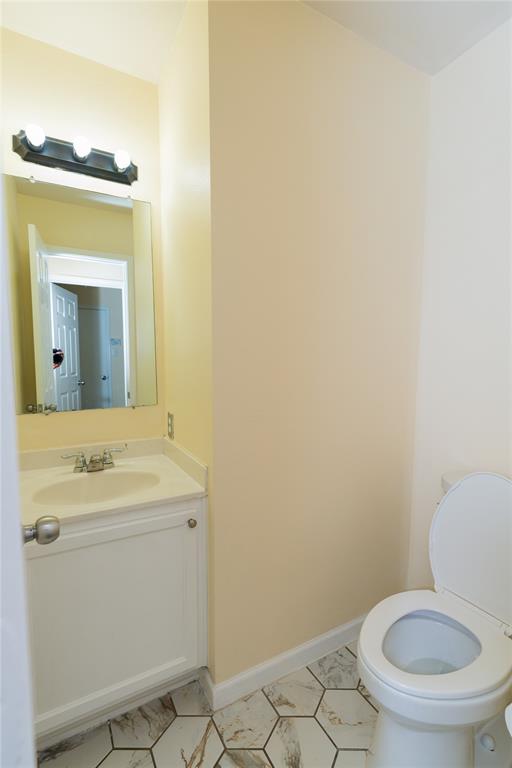 1717 Shawnee Trail Allen, TX 75002 - Photo 7 of 35 a bathroom with a toilet sink vanity and mirror