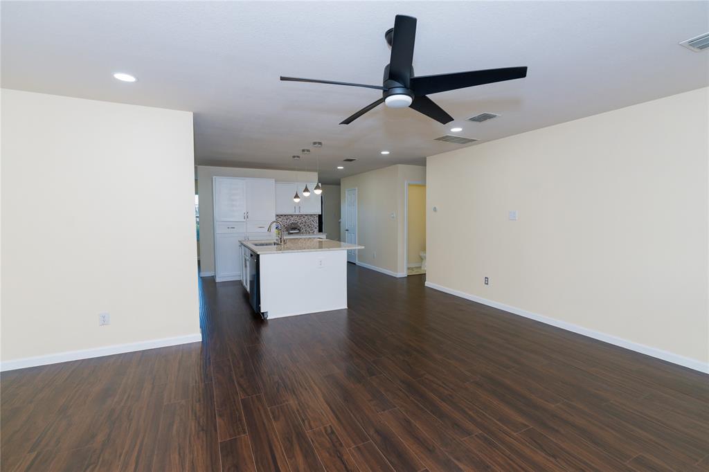 1717 Shawnee Trail Allen, TX 75002 - Photo 9 of 35 a view of a kitchen with a sink a ceiling fan and wooden floor