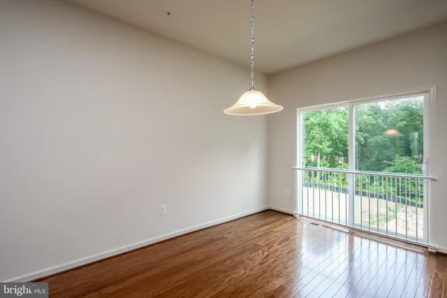 en empty room with wooden floor and chandelier