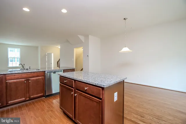a kitchen with stainless steel appliances granite countertop a sink and wooden floor