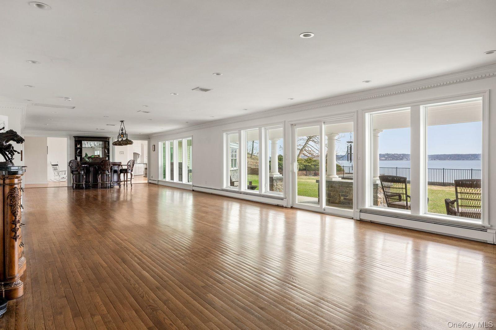 33 Beach Road Northport, NY 11768 - Photo 9 of 50 a view of empty room with wooden floor and floor to ceiling windows