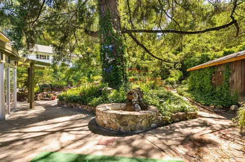 a view of a patio with table and chairs potted plants and floor to ceiling window