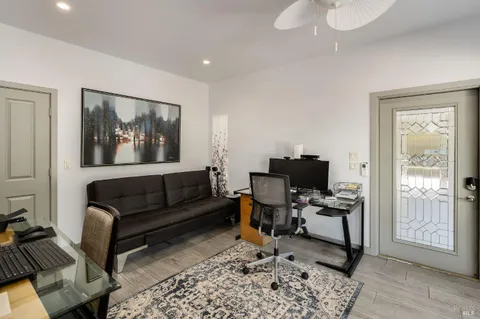 a living room with furniture a flat screen tv and floor to ceiling window