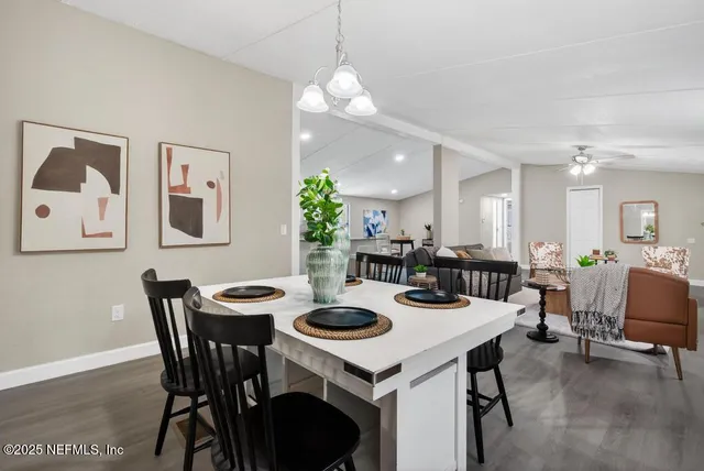 a kitchen with kitchen island granite countertop wooden floors and white cabinets
