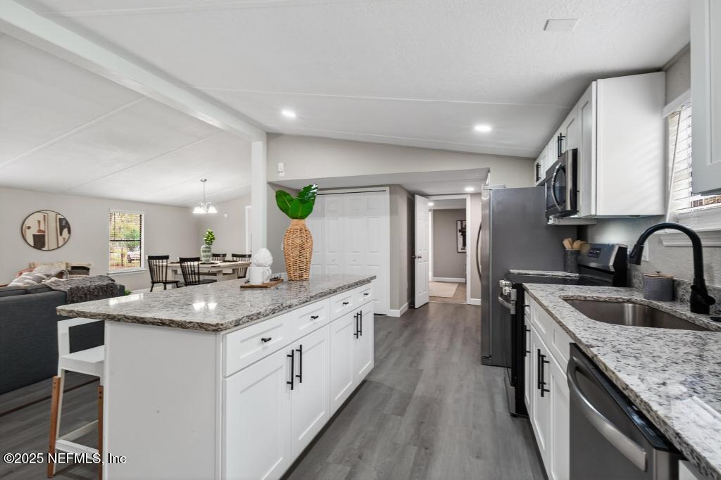 95422 Plum Loop Fernandina Beach, FL 32034 - Photo 28 of 76 a kitchen with stainless steel appliances granite countertop a sink stove and cabinets