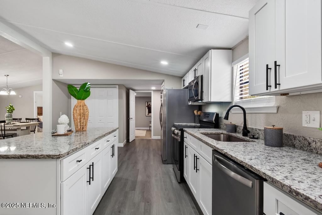 95422 Plum Loop Fernandina Beach, FL 32034 - Photo 29 of 76 a large kitchen with stainless steel appliances granite countertop a lot of counter space and wooden floor