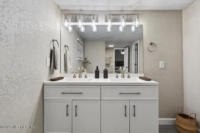 an empty room with wooden floor chandelier fan and windows