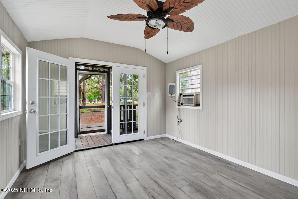 95422 Plum Loop Fernandina Beach, FL 32034 - Photo 55 of 76 an empty room with wooden floor chandelier fan and windows