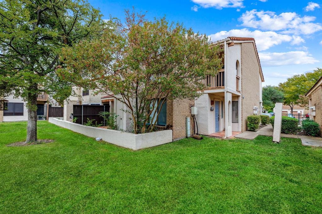 a front view of a house with a yard and trees