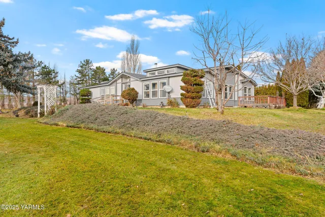 a view of a large white house with a yard