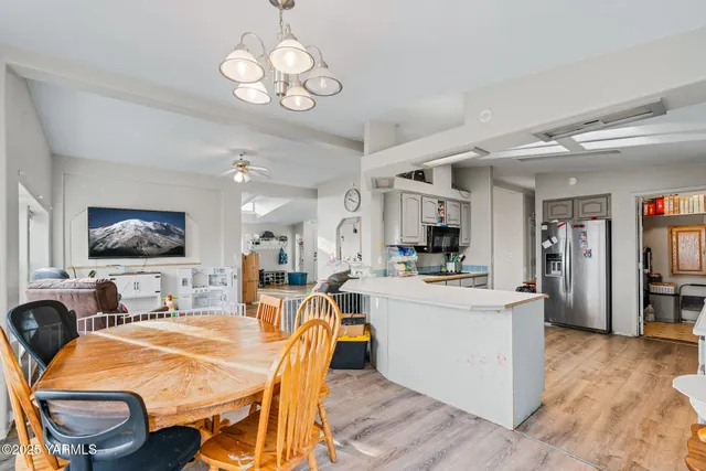 a dining room with wooden floor and stainless steel appliances