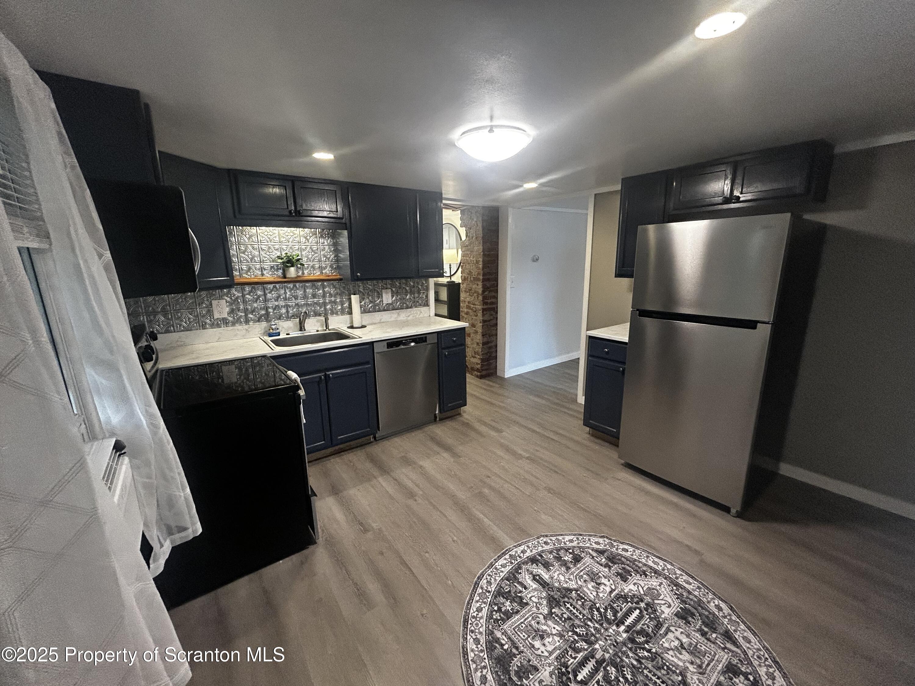 1214 Mine Street Old Forge, PA 18518 - Photo 7 of 21 a kitchen with stainless steel appliances granite countertop a refrigerator a sink a stove and island