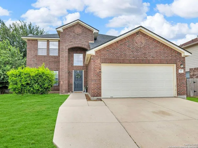 a front view of a house with yard and garage