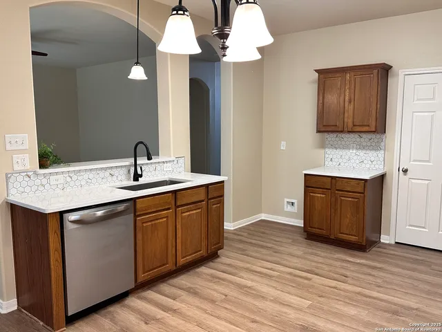 a kitchen with a sink and wooden floor