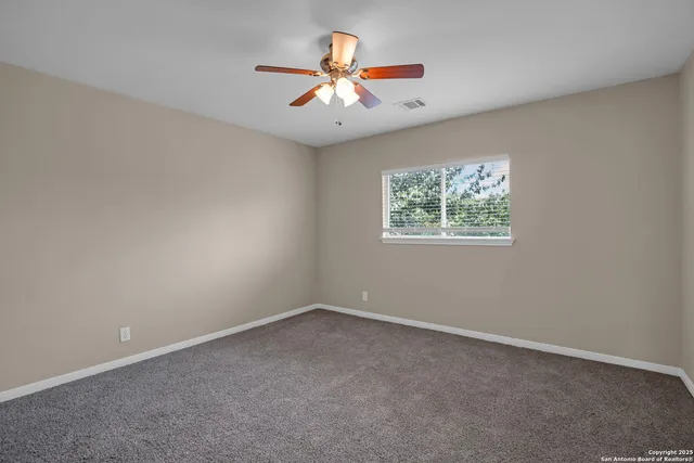 an empty room with closet and a chandelier fan