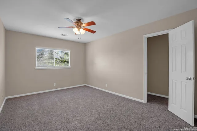 an empty room with a chandelier fan
