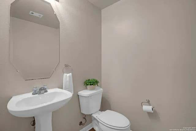 a bathroom with a sink toilet and a mirror