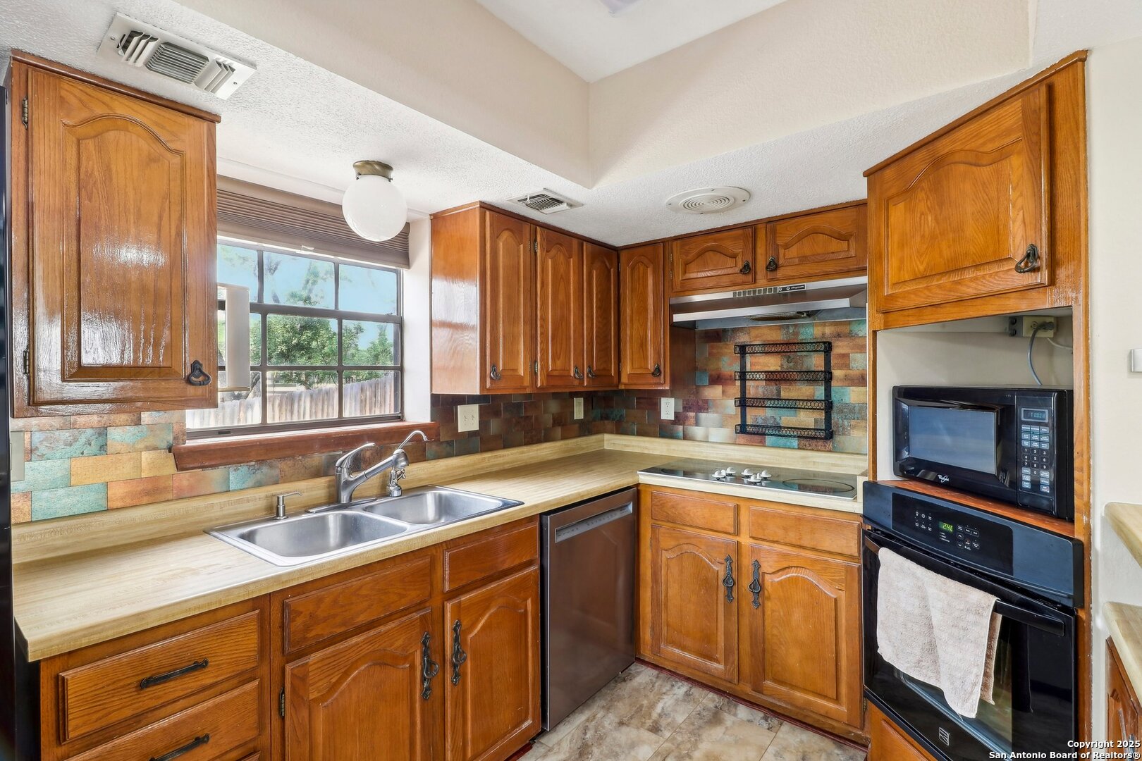 1551 Pebble Beach Road Lakehills, TX 78063 - Photo 15 of 46 a kitchen with a sink cabinets and window