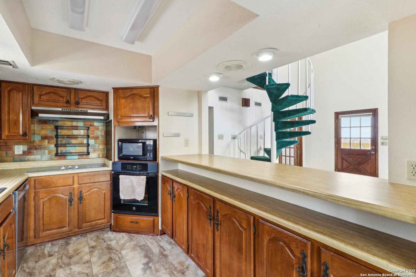 1551 Pebble Beach Road Lakehills, TX 78063 - Photo 16 of 46 a spacious kitchen with stainless steel appliances granite countertop a sink and cabinets
