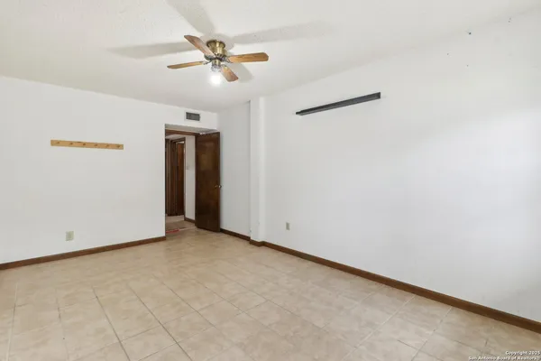 an empty room with a ceiling fan and a window
