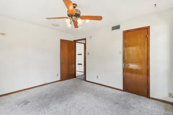an empty room with a chandelier fan