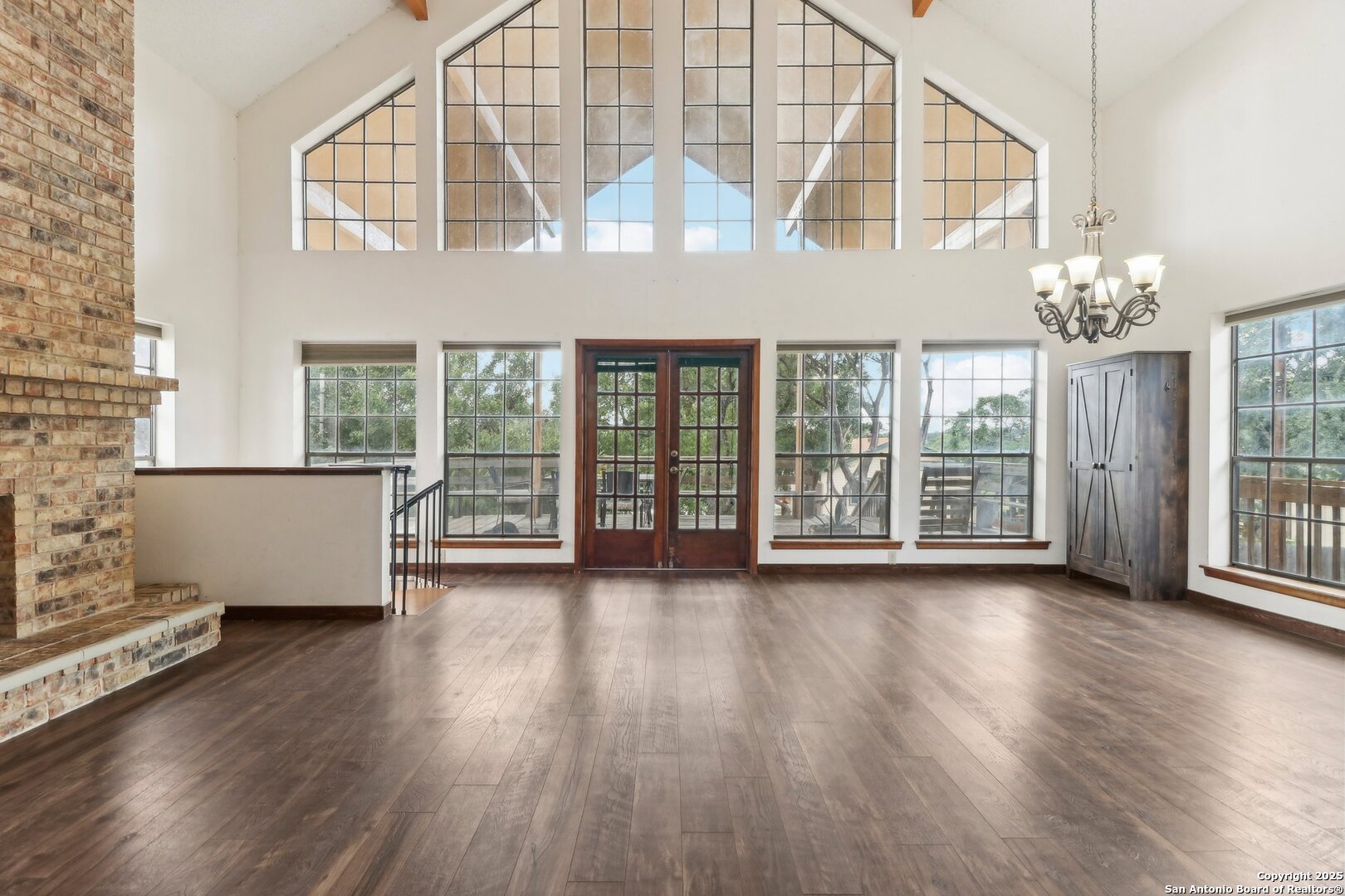 1551 Pebble Beach Road Lakehills, TX 78063 - Photo 3 of 46 an empty room with wooden floor and windows