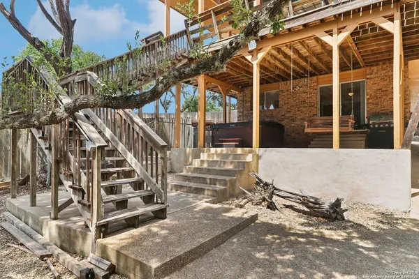 a view of balcony with two chairs and wooden fence
