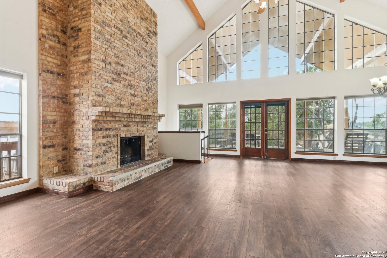 1551 Pebble Beach Road Lakehills, TX 78063 - Photo 4 of 46 a view of an empty room with wooden floor and a fireplace