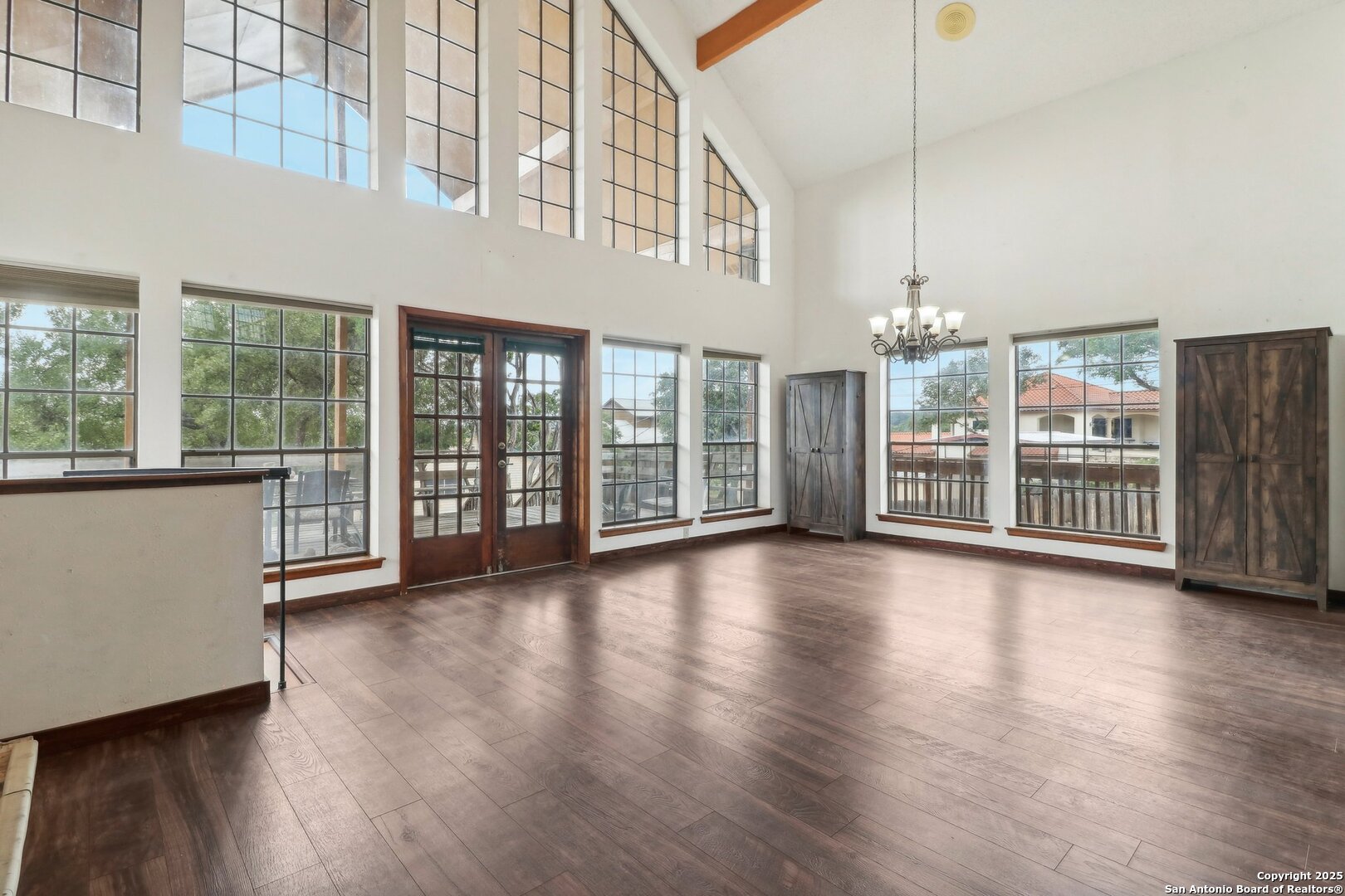 1551 Pebble Beach Road Lakehills, TX 78063 - Photo 5 of 46 a view of a big room with wooden floor windows and a living room