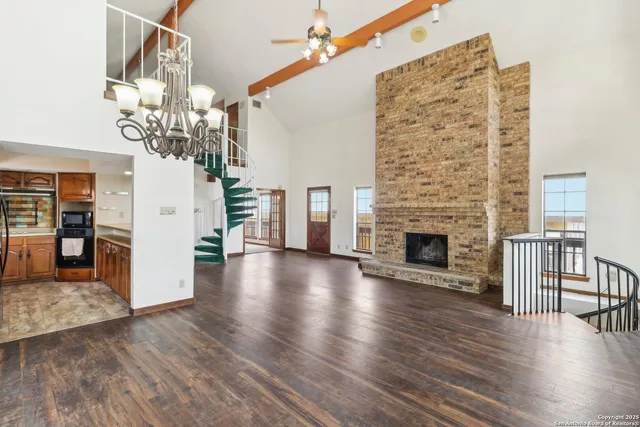 a view of a livingroom with wooden floor and a fireplace