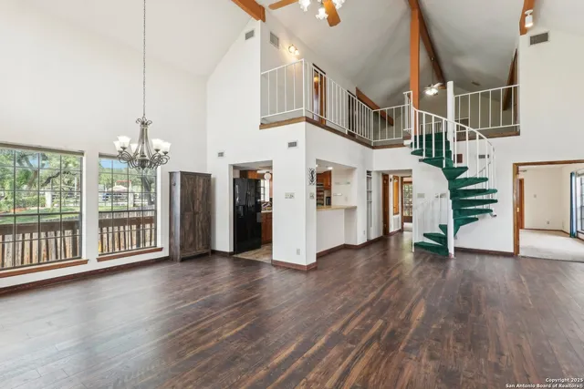 a view of a big room with wooden floor and windows