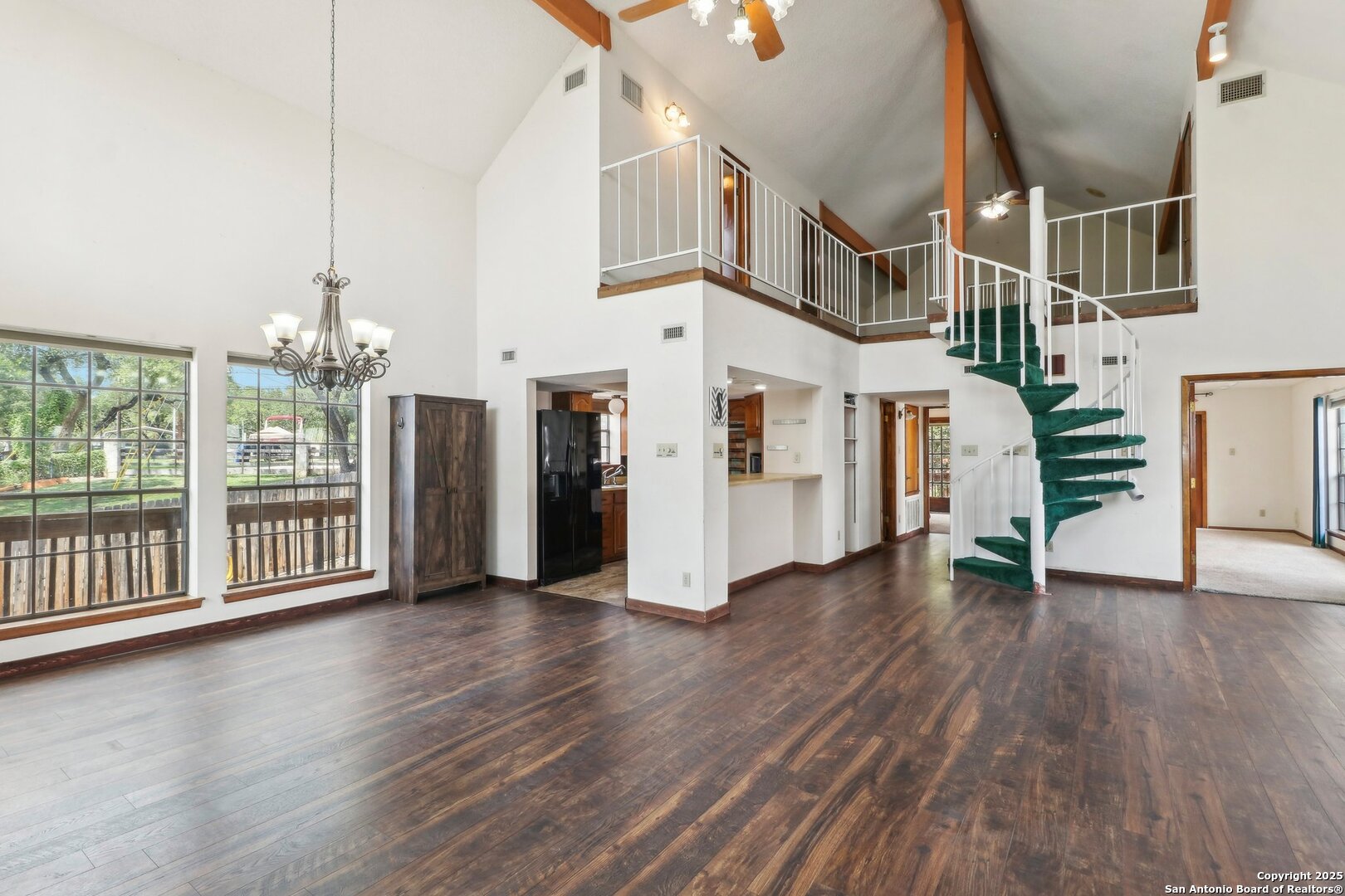 1551 Pebble Beach Road Lakehills, TX 78063 - Photo 9 of 46 a view of a big room with wooden floor and windows
