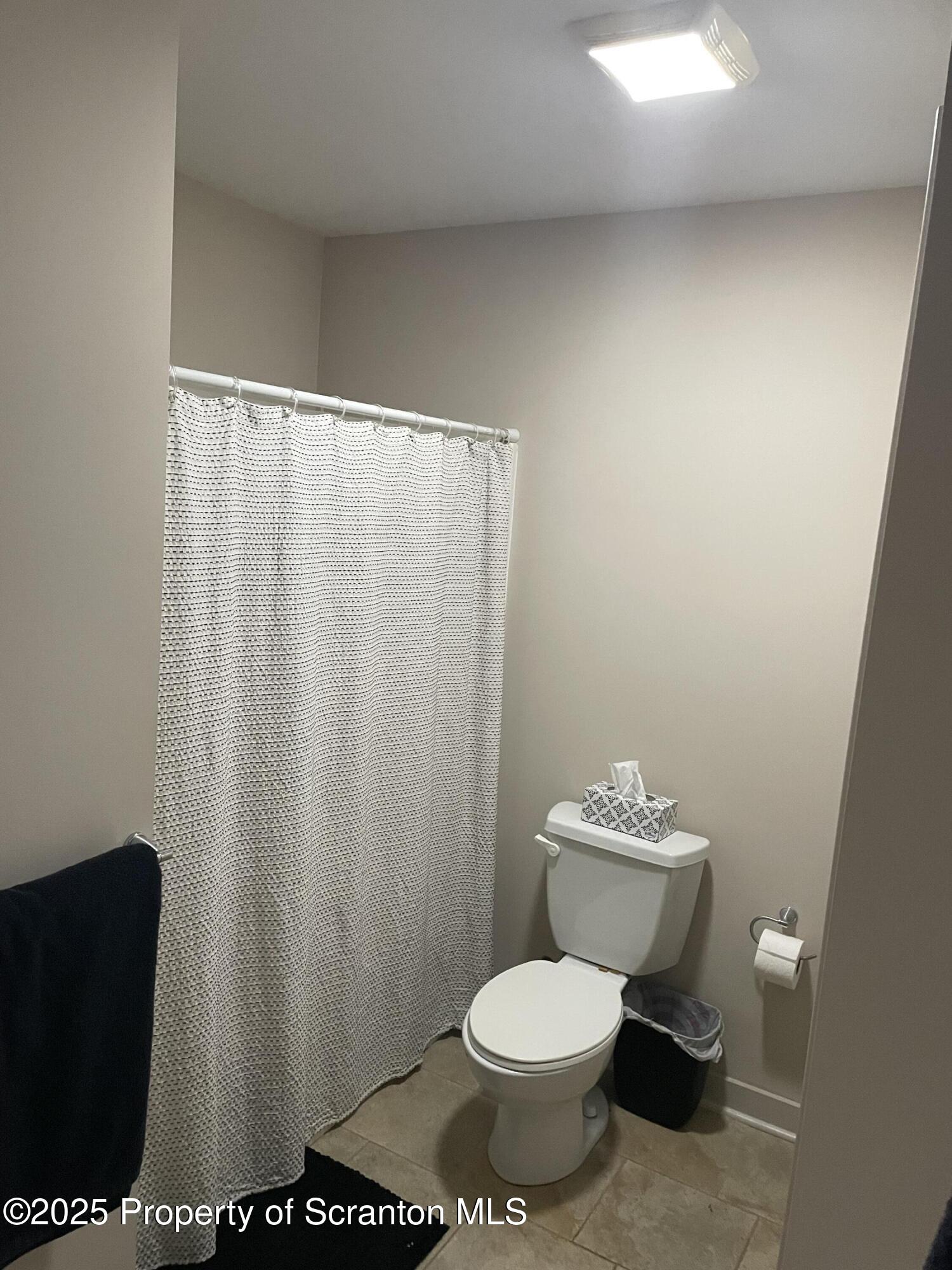 320 Penn Avenue, Unit 9 Scranton, PA 18503 - Photo 5 of 6 a white toilet sitting next to a shower curtain