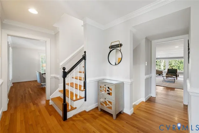 a view of a hallway with wooden floor and staircase